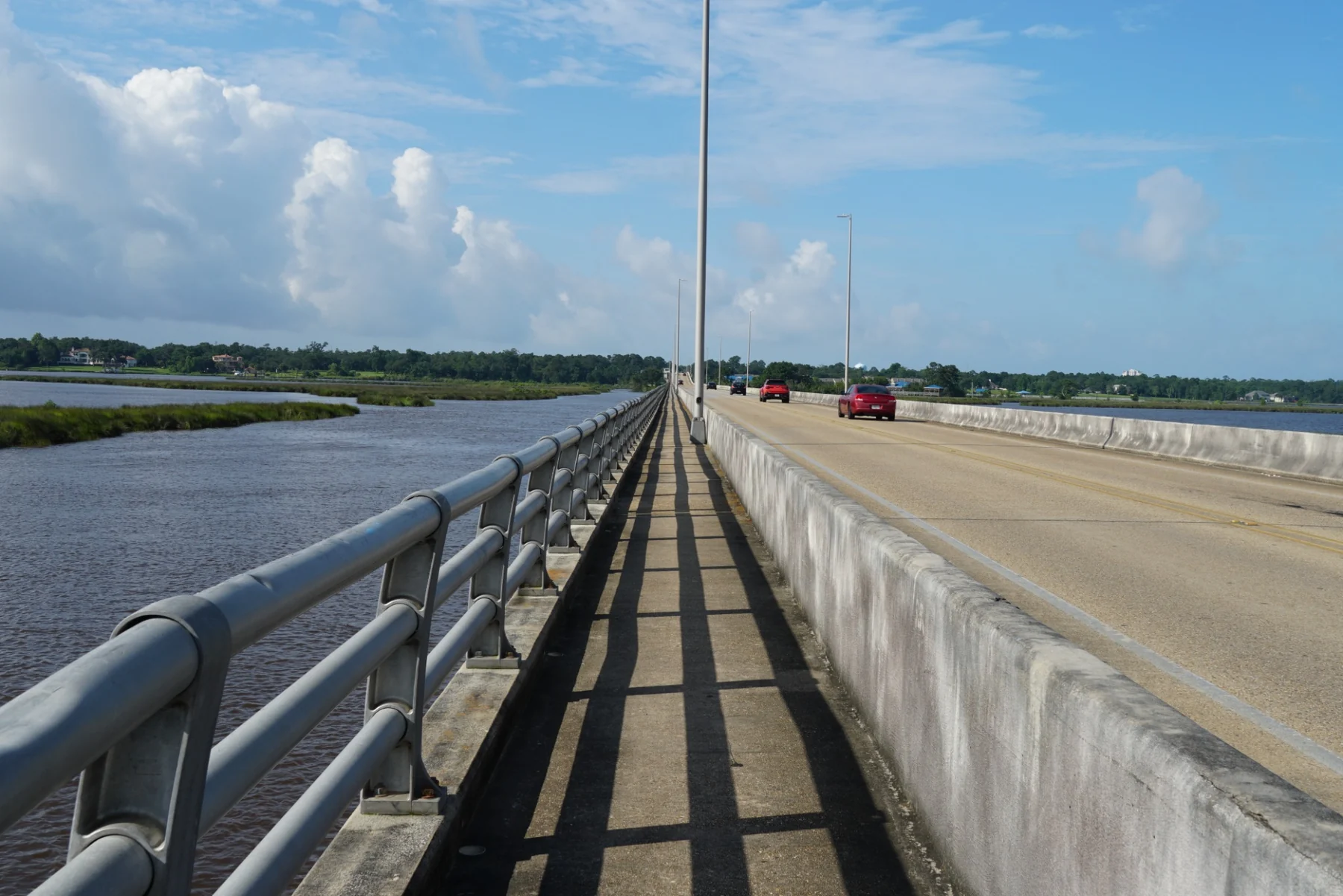 Original camera shot of the Popps Ferry bridge sidewalk with traffic beside it